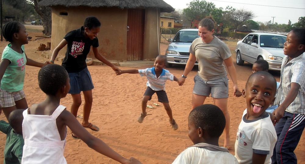 博茨瓦纳的孩子和Pitzer的学生手拉手围成一个圈.